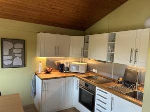 a kitchen with white cabinets and a counter top at DeichLand117 in Butjadingen