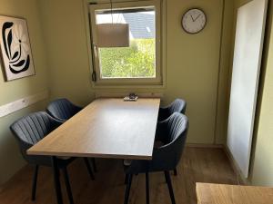 a table and chairs in a room with a clock at DeichLand117 in Butjadingen