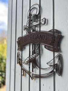 a metal doorhandle with a sign on a wall at DeichLand117 in Butjadingen +12 photos