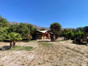 a house in the middle of a field with palm trees at Refugio Escondido in Isla de Maipo