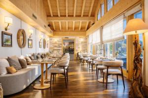 a restaurant with couches and tables and chairs at Chalet RoyAlp Hôtel & Spa in Villars-sur-Ollon