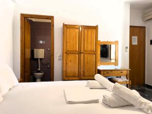 a bedroom with a bed with white towels on it at Lenitsa Central Parga Rooms in Parga