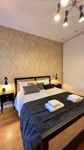 a bedroom with a large bed with two towels on it at Colosseo Deluxe YH in Rome