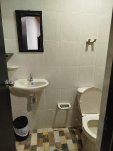 a bathroom with a sink and a toilet and a mirror at Hotel Casa Real Málaga Santander in Málaga