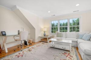 a living room with a white couch and a table at Captain's Row: Pool, Tennis Chatham Charm in Chatham