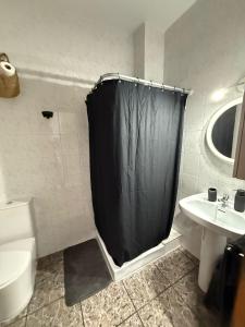 a bathroom with a black shower curtain and a sink at Fina beach in Nules +6 photos