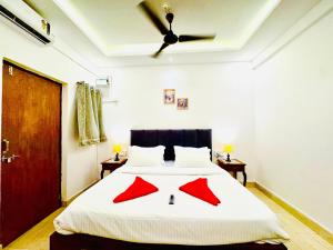 a bedroom with a bed with red sheets and a ceiling at FabHotel Elvin's Place in Calangute