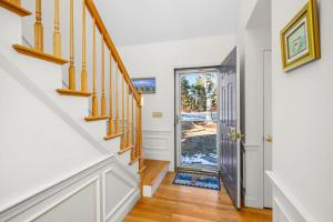 a hallway with white walls and a staircase with a door at Lake front, Near Beach, AC, WiFi, Pet Friendly near Bike Path in Chatham