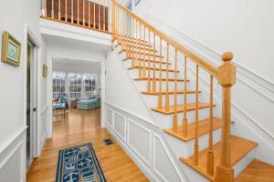 a staircase in a home with white walls at Lake front, Near Beach, AC, WiFi, Pet Friendly near Bike Path in Chatham +73 photos