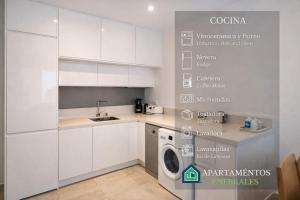 a kitchen with white cabinets and a washing machine at Enebrales 304 in Punta Umbría