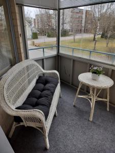 a wicker chair sitting on a balcony with a table at Varakoti Helmi in Loimaa