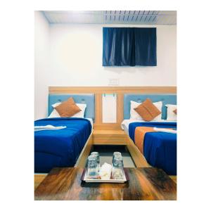 a room with two beds and a tray of food on a table at Jazz residency hotel in Mumbai