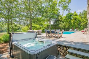 a hot tub on a patio next to a pool at Bay Breeze Escape—Pool, Game Room Views in Centerville