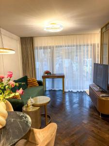 a living room with a green couch and a tv at Vilnius Luxurious flat in Vilnius