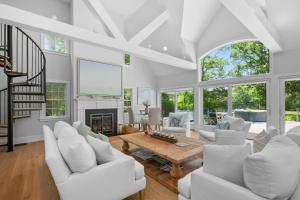a living room with white furniture and a fireplace at Bay Breeze Escape—Pool, Game Room Views in Centerville