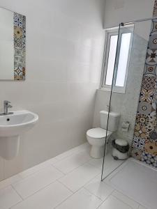 a white bathroom with a toilet and a sink at Azure Dome Residences in Għajnsielem +7 photos