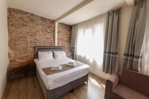 a bedroom with a bed and a brick wall at Angela Inn Boutique in Istanbul