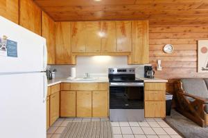 a kitchen with wooden cabinets and a white refrigerator at Chalet #18 in Stevensville