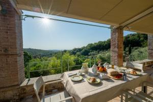 a table with plates of food on top of a balcony at Poggio del Raglio in Trequanda