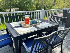 a black table with a drink on it on a deck at Beach Glass—Space, Fun Furry Friends Welcome in Brewster
