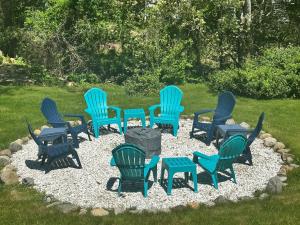 a group of chairs sitting in a circle in a yard at Beach Glass—Space, Fun Furry Friends Welcome in Brewster