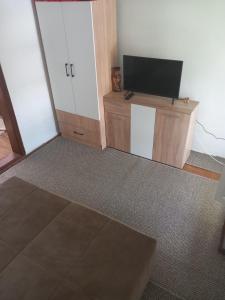 a living room with a flat screen tv on a cabinet at Apartman Cicović in Foča