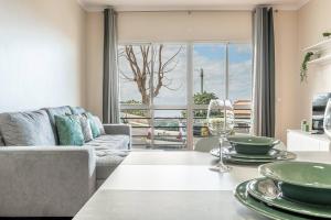 a living room with a couch and a table at Emerald Scape Garajau Madeira Cristo Rei Area in Caniço