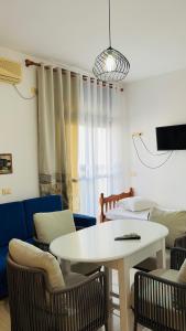 a living room with a white table and chairs at Villa JURGEN in Durrës