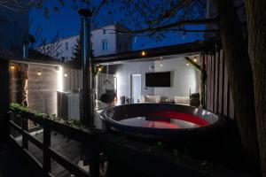 a bath tub in the yard of a house at night at BDSM room Bydgoszcz z jacuzzi dużym tarasem i Balią zewnętrzną in Bydgoszcz +29 photos