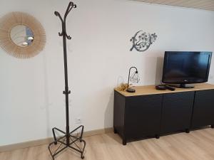 a room with a television on a dresser with a mirror at Charmant studio au rez de chaussée in Arbois