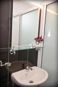 a bathroom with a sink and a mirror at Meili Lanka City Hotel in Kandy