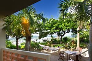 a hammock on a porch with a view of the beach at Coco Garden Resort Okinawa in Uruma