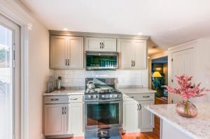a kitchen with white cabinets and a stove top oven at Cape Cod Home—Deck, Near Canal Bike Path in Sandwich +19 photos