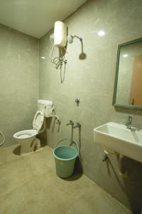 a bathroom with a toilet and a sink and a bucket at Icon vista hotel in Tirupati