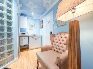 a living room with a chair and a kitchen at Maison Des Jardins B & B in Montreal