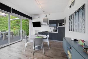 a kitchen and dining room with a table and chairs at Residence La Mignon Terrazza in Torri del Benaco +21 photos