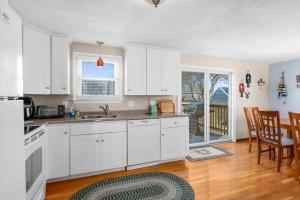 a kitchen with white cabinets and a table and chairs at Family Cape Escape—Beach, Boardwalk Game Room in Sandwich +21 photos