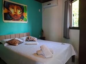 a bedroom with a bed with towels on it at Pousada Toa Toa Em Pipa in Pipa