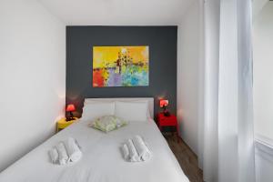 a bedroom with a white bed and a painting at Residence La Mignon Terrazza in Torri del Benaco