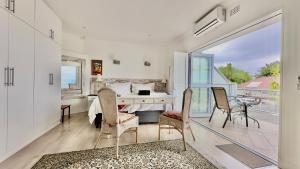 a bedroom with a bed and a desk and chairs at Somerset View Guest House in Somerset West