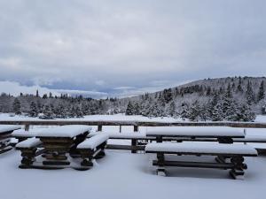 a group of picnic tables covered in snow at Auberge du Mas de la Barque in Villefort