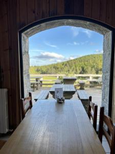 a large wooden table with a view of a deck at Auberge du Mas de la Barque in Villefort +27 photos