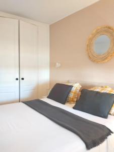 a bedroom with a large white bed with a mirror at Apartamento Verdemare in Corralejo +60 photos