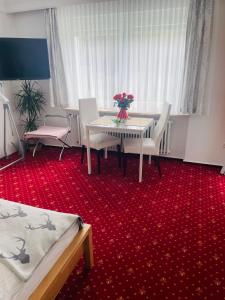 a room with a table with a vase of flowers on it at Haus Anna-Marie in Feldberg