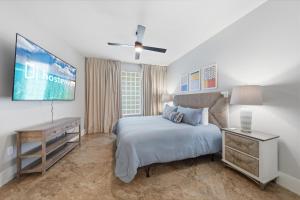 a bedroom with a bed and a desk and a tv at Bella Luna 908 in Orange Beach