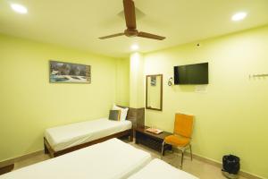 a hospital room with two beds and a flat screen tv at Icon vista hotel in Tirupati
