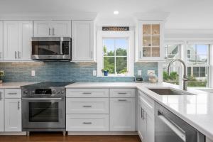 a white kitchen with a sink and a stove at Happy As A Clam in Chatham