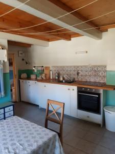a kitchen with white cabinets and a stove top oven at Ferienhaus Petersen in Langeneß