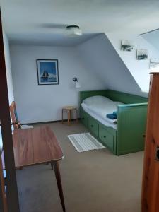 a small room with a bed and a table at Ferienhaus Petersen in Langeneß
