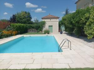 a swimming pool in a yard with a house at Le Couvent in Lagardelle